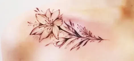 A branch of flower tattoo on the woman's shoulder