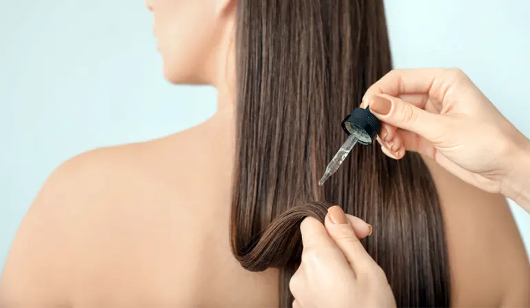 Applying hair serum on straight hair